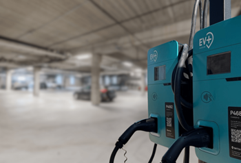 A charging station for electric vehicles is shown in a parking garage.